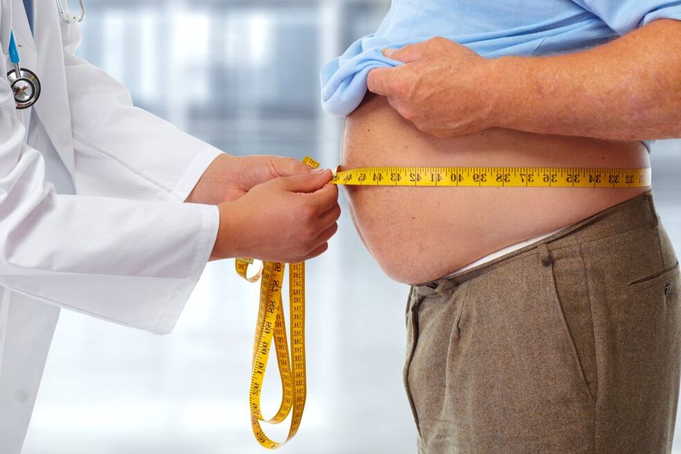 Ο γιατρός μετρά τη μέση του ασθενούς κατά τη διάρκεια μιας δίαιτας